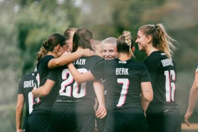 Die Spielerinnen des FC Viktoria Berlin feiern in schwarzen Trikots den Sieg gegen Türkiyemspor.